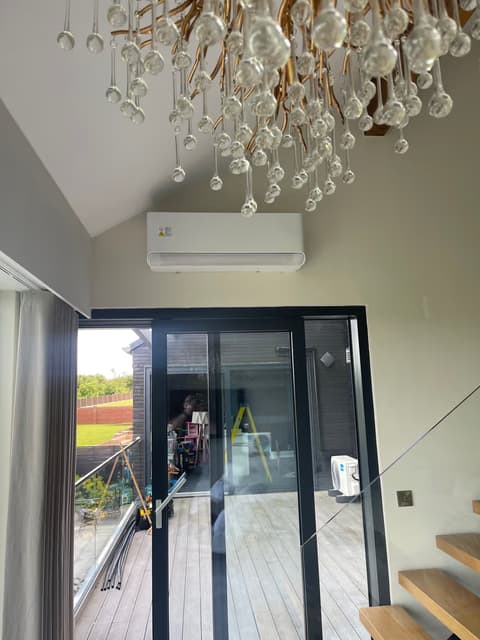Wall-mounted air conditioner in a vaulted extension with bi-fold doors